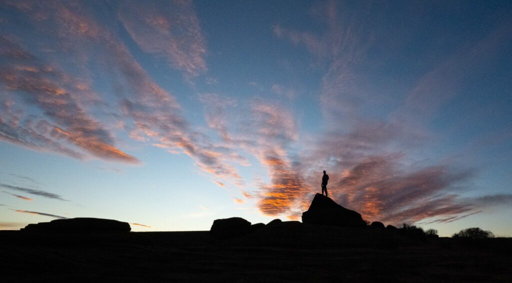 Man on rock at sunrise Horseshoe Bend AZ